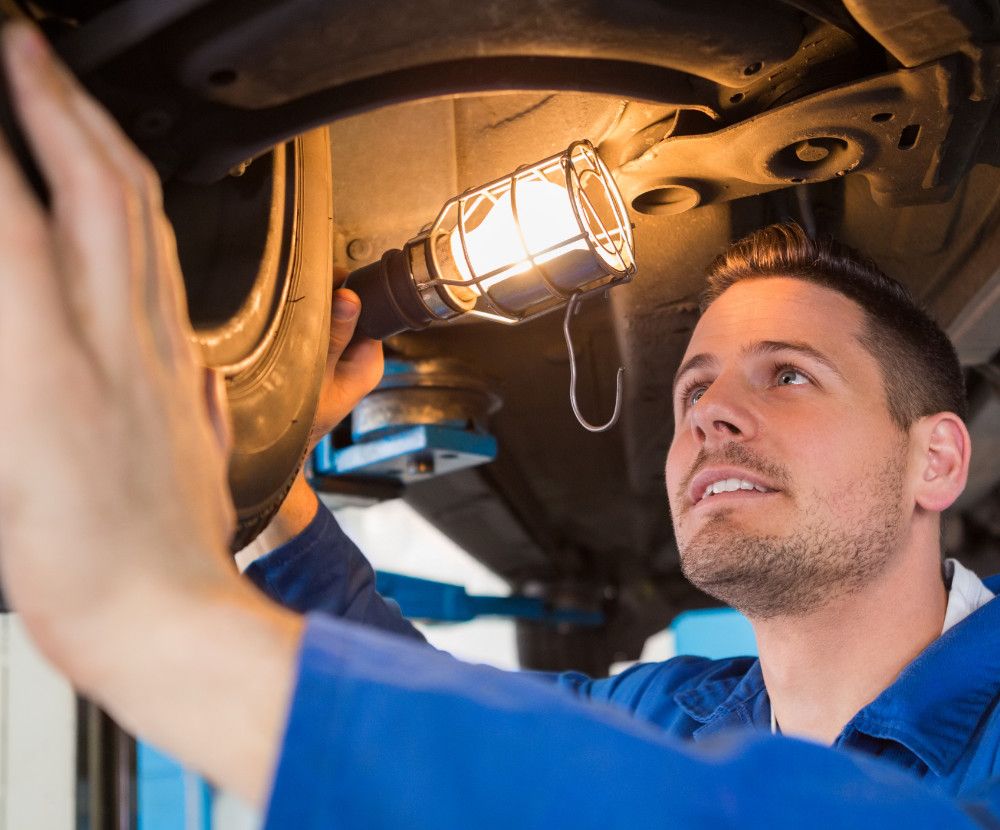 Mechanic underneath a vehicle during its MOT Liverpool